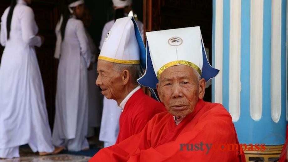 Two Cao Dai elders before the service.  Their hats bear...