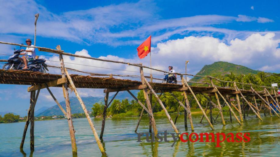 An old wooden bridge between 2 small villages along a...