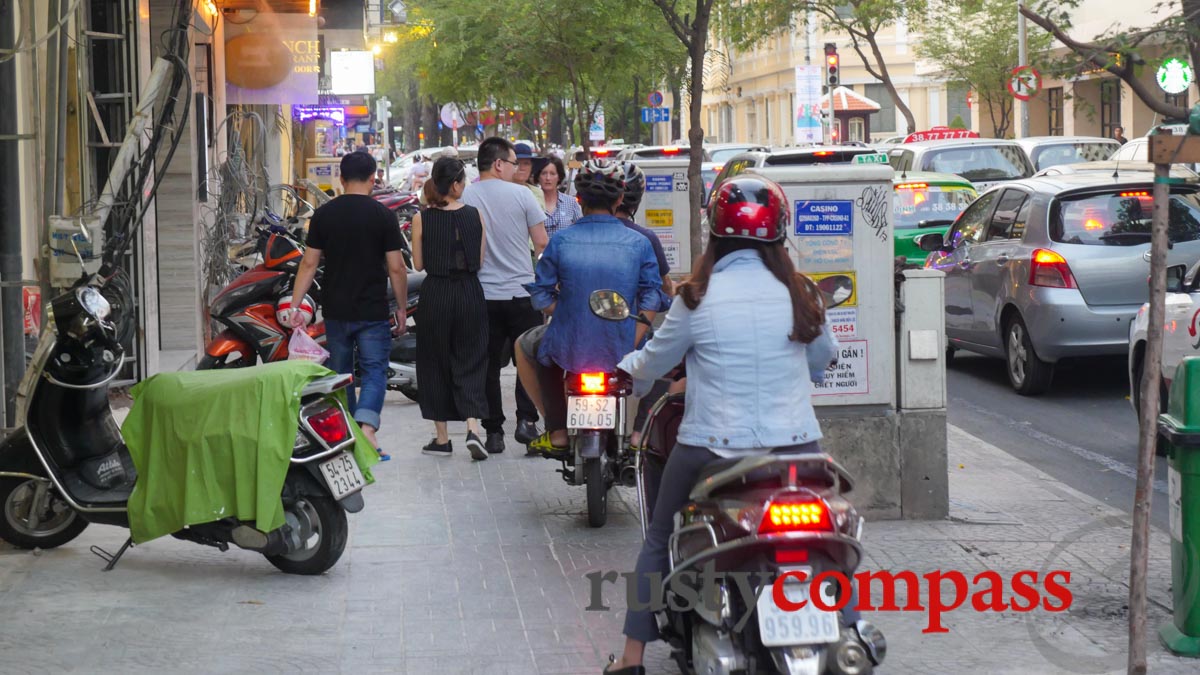 Motorbikes colonise the pavements. Saigon's tourist centre this week.