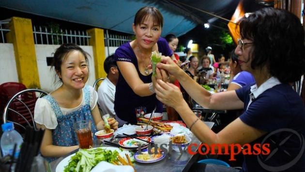 Chi Mai at Ba Le Well restaurant gives these Japanese travellers a lesson in wrapping their delicious fresh rolls.