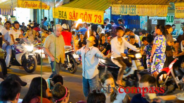 Young fire-eater struggles for attention on Beer St, Saigon