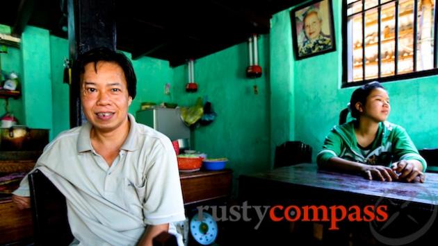 Mr Binh of Com Ga Ba Buoi. Here he sits with his daughter. His mother, Ba Buoi watches on from behind. She started the small eatery in the 1950s.