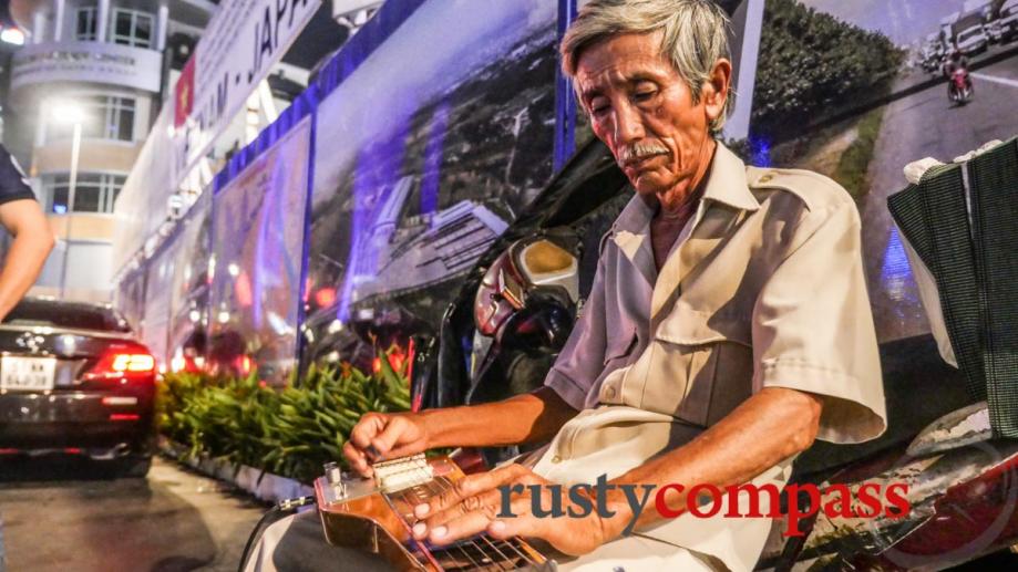 Mournful slide guitar bounces around Saigon's Nguyen Hue pedestrian street.