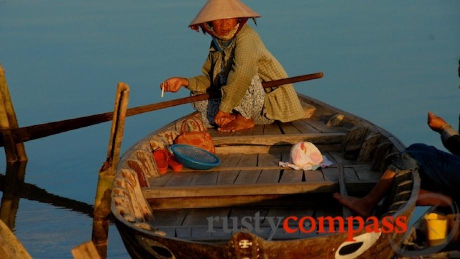 Boat woman enjoys a late afternoon smoke.