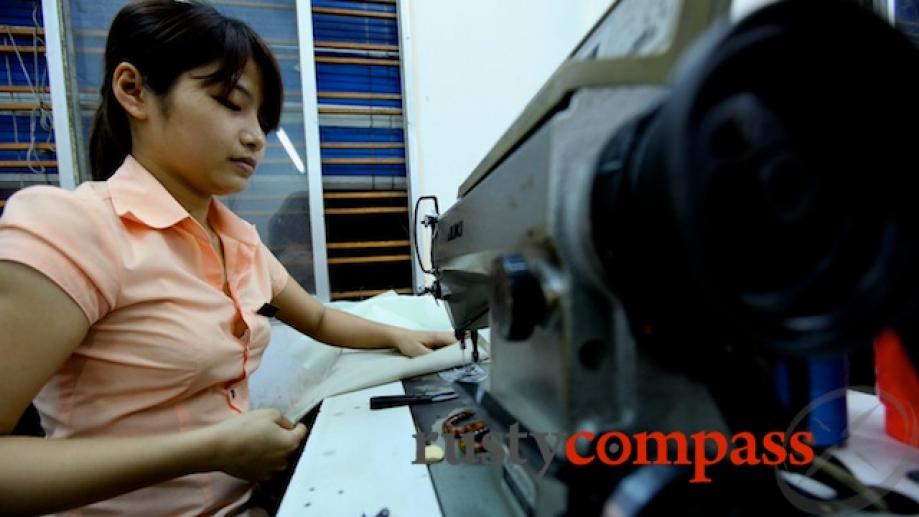 Hoi An tailor hard at work churning out garments for...